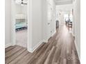Bright hallway featuring modern gray wood flooring, leading to a bedroom and dining area at 5367 Turtle Creek Dr, Denver, NC 28037