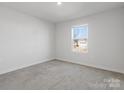 Minimalist bedroom features neutral carpet, white walls and one window providing natural light at 609 Grandiflora Ave, Lancaster, SC 29720
