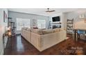 Spacious living room featuring hardwood floors, a fireplace, and large windows at 6618 Alexander Rd, Charlotte, NC 28270