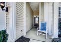 Close-up of a welcoming front porch featuring a comfortable rocking chair and stylish columns at 9005 Smokey Hill Ln, Indian Land, SC 29707