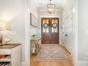 Bright foyer featuring hardwood floors, decorative rug, double doors, and elegant decor at 9260 Ahavah Ln, Indian Trail, NC 28079
