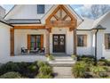 Inviting front porch featuring a seating area and a beautifully decorated double door entryway with wooden beams at 9260 Ahavah Ln, Indian Trail, NC 28079