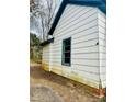 Side view of the house with blue trim window, siding, and partial brick foundation visible at 981 15Th St # 16, Lancaster, SC 29720