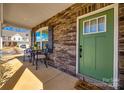 Inviting front porch with stone accents and a vibrant green door, perfect for enjoying quiet moments outdoors at 10379 Black Locust Ln, Charlotte, NC 28215