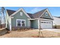 Charming one-story home with a two-car garage and landscaped yard, set against a blue sky at 134 Montgomery Pl # 708, Mount Gilead, NC 27306