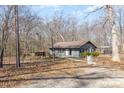 Quaint single-story home with a gray exterior, wooden porch, and natural wooded surroundings at 135 Natures Way, Mount Holly, NC 28120