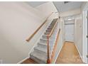 Inviting entryway featuring hardwood floors, carpeted staircase and white front door at 15662 King Louis Ct, Charlotte, NC 28277