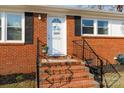 Close up of the front door showcasing the brick stairs, iron railings, and welcome decoration at 1597 Mcgill St, Rock Hill, SC 29732