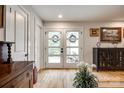 Inviting entryway featuring hardwood floors, white trim, and stylish double doors with wreaths at 16137 Tana Tea Cir, Tega Cay, SC 29708