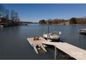 Lake view featuring a boat dock and boat lift on a sunny day, perfect for watersports and relaxation at 170 W Maranta Rd, Mooresville, NC 28117