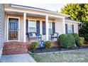 Inviting front porch with wicker furniture, decorative pillows, and landscaped flower bed at 217 Pine Meadows Cir, Hickory, NC 28601