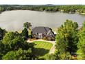 Aerial view of waterfront home with lush landscaping, a sprawling lawn and access to a serene lake at 249 Blue Heron Dr, Rock Hill, SC 29732