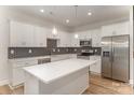 Modern kitchen featuring stainless steel appliances, white cabinetry, a center island, and a gray hexagon backsplash at 2816 Old Steele Creek Rd, Charlotte, NC 28208
