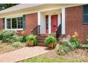 Inviting brick front entrance with a red door and manicured landscaping at 329 N Oakwood Dr, Statesville, NC 28677