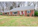 Charming brick home with manicured lawn, mature trees, and a welcoming front entrance at 329 N Oakwood Dr, Statesville, NC 28677