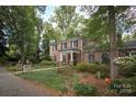 Brick home with manicured landscaping, stone pathway and many mature trees at 419 Park Ridge Rd, Albemarle, NC 28001
