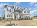 Beautiful two-story home featuring white siding, dark shutters, and a landscaped front yard with stone accents at 4604 Howie Ln, Harrisburg, NC 28075