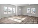 Bright living room boasts large windows, providing abundant natural light and highlighting the hardwood floors at 5102 Shasta St # 5102, Gastonia, NC 28052