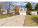 Traditional two-story home with attached two-car garage and long driveway offering ample parking space at 9138 Babbitt Way, Charlotte, NC 28216