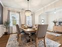 Elegant dining room with a chandelier, large windows, and a table set for a formal meal at 1017 Cheviot Ct, Waxhaw, NC 28173