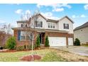Charming two-story house boasting a brick and siding exterior, two-car garage and landscaped front yard at 11296 Serenity Farm Dr, Midland, NC 28107
