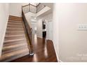 Foyer with hardwood floors, staircase, and open view to the kitchen at 113 Burlingame Ct # D, Mooresville, NC 28117