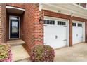 Close-up of brick townhome facade showing front door, garage, and landscaped entryway at 113 Burlingame Ct # D, Mooresville, NC 28117