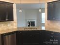 Open-concept kitchen with granite countertops, stainless steel appliances, and dark cabinetry at 113 Burlingame Ct # D, Mooresville, NC 28117