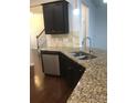 Kitchen island featuring granite countertops, stainless steel dishwasher, and dark cabinetry at 113 Burlingame Ct # D, Mooresville, NC 28117
