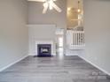 Spacious living room featuring fireplace, ceiling fan, and staircase to upper level at 12601 Tucker Crossing Ln, Charlotte, NC 28273