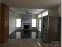 Open living room features hardwood floors, a stone fireplace, and glass doors leading to the backyard at 12662 Woodside Falls Rd, Pineville, NC 28134