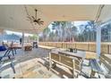 Inviting outdoor dining area on a covered patio, featuring a fan and view of the expansive, fenced backyard at 136 Falls Leaf Dr, Troutman, NC 28166