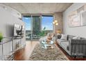 Bright living room with concrete ceilings, wood floors, a large balcony, and city views at 210 N Church St # 1612, Charlotte, NC 28202