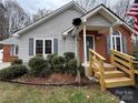 Inviting exterior of a single-story home with brick accents, grey siding, and a wooden handicap accessible ramp at 3008 Overlook Trl, Charlotte, NC 28212