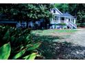 Home exterior featuring a well-maintained lawn, covered porch with white railings, and mature trees at 315 Confederate St, Fort Mill, SC 29715