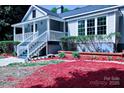 Home featuring an inviting front porch, tidy landscaping, and decorative brick mulch at 315 Confederate St, Fort Mill, SC 29715
