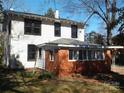 Two-story home with visible window frames and a brick sun room at 322 E Houston St, Monroe, NC 28112