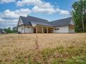 The backyard features a covered porch and an expansive yard, perfect for outdoor living and entertaining at 4024 Landsford Rd, Marshville, NC 28103