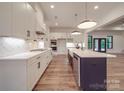 The kitchen is designed with white cabinets, a large island, and modern stainless steel appliances at 4024 Landsford Rd, Marshville, NC 28103