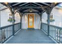 Charming covered front porch with a decorative door, welcome sign, and flower boxes at 547 Lake Shore Dr, Norwood, NC 28128
