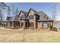 This beautiful brick home features unique architectural design, beautiful landscaping, and lake at 5628 Creole Rd, Clover, SC 29710