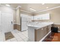 Bright kitchen featuring white cabinetry, modern appliances, and tiled flooring at 8923 Meadow Vista Rd, Charlotte, NC 28213
