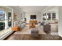 Bright, staged living room with hardwood floors, neutral-toned furniture, and large windows at 9203 Christina Marie Ct, Charlotte, NC 28213