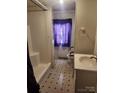 Compact bathroom with sink, toilet, shower, and patterned flooring at 105 Mcgill Nw Ave, Concord, NC 28025