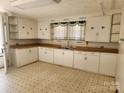 A spacious kitchen with ample cabinet storage and tile floors that's ready for its next homeowner at 105 Mcgill Nw Ave, Concord, NC 28025