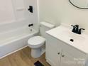 Clean bathroom featuring a white vanity, toilet, and bathtub with a black shower head at 111 Dove Cir, Statesville, NC 28625