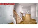 Bright entryway with wood-look flooring, staircase, and views into the open-concept living spaces at 11217 Cardinal Creek Ave, Charlotte, NC 28215