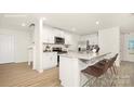 Eat-in kitchen features white cabinets, stainless appliances, granite countertops, and seating at the island at 11217 Cardinal Creek Ave, Charlotte, NC 28215