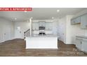 Bright, open-concept kitchen with large island, granite counters, stainless appliances and hardwood floors at 11225 Cardinal Creek Ave, Charlotte, NC 28215