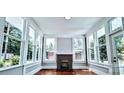 Sunroom features beautiful wood flooring, lots of natural light, and a brick fireplace at 113 Brawley St, Chester, SC 29706
